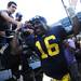 Michigan senior quarterback Denard Robinson smiles as he high-fives fans while making his way off the field and up the tunnel after beating UMass 63-13 at Michigan Stadium on Saturday. Melanie Maxwell I AnnArbor.com